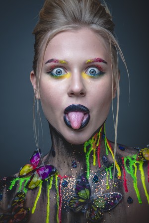 Young girl with creative makeup with butterflies